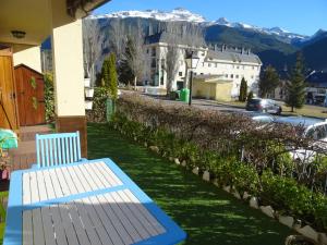 un banco azul sentado en un balcón con una montaña en Vista Collarada, en Villanúa