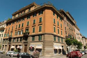 een groot bakstenen gebouw met auto's geparkeerd voor het bij Hotel Al SanPietrino in Rome
