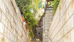 an alley between two buildings with plants at Guest house AllineedDubrovnik Choose between Double room or penthouse or studio apartments FREE PARKING in Dubrovnik