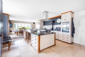 a kitchen with white cabinets and a large kitchen island at Copse Gate Farm in Bridport