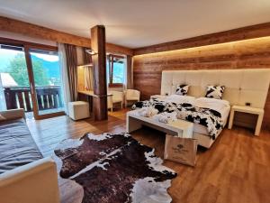 een slaapkamer met een bed en een bank bij Parkhotel Ladinia in San Vito di Cadore