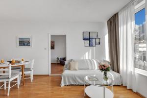 a white living room with a couch and a table at Apartman Bonaca in Baška Voda