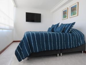 a bed with a blue comforter in a bedroom at Penthouse Bahía Fragata in San Andrés