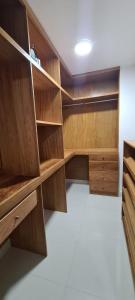 an empty closet with wooden shelves and cabinets at AMG Suites Apartment in Santo Domingo