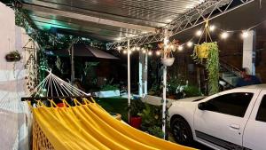 a yellow hammock in a parking lot with a white car at Rincón de Kike in Villeta