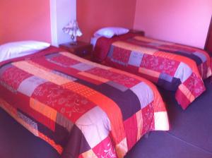 two beds sitting next to each other in a room at Hostal Tres Máscaras in Ayacucho