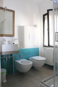 een badkamer met een wastafel, een toilet en een spiegel bij B&B MARIMA 2 POSTI ORGOSOLO in Orgosolo