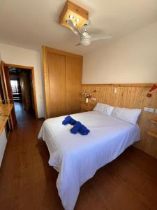- une chambre avec un lit et une serviette bleue dans l'établissement Casa Las Nasas, à El Cotillo