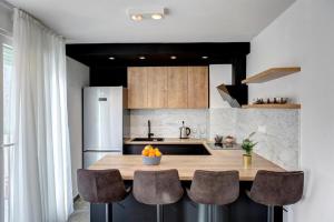 een keuken met een aanrecht met stoelen en een koelkast bij Luxury apartment Olivia in Mostar