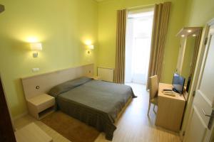 a bedroom with a bed and a desk with a computer at Alojamento Local Primavera in Amadora