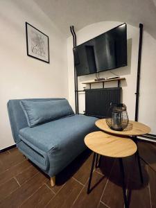 uma sala de estar com um sofá azul e uma mesa em Dorfel em Košice