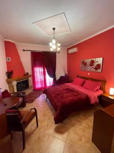 カト・ルートラキにあるAsteras Hotelの赤い壁のベッドルーム1室(大型ベッド1台付)