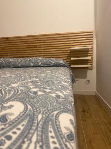 une chambre avec un lit et une tête de lit en bois dans l'établissement Kefalure, à Cefalù