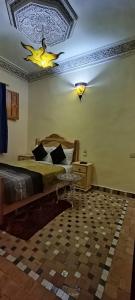 - une chambre avec un grand lit et un lustre dans l'établissement Riad lala Drissia, à Fès