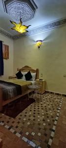 Riad lala Drissia في فاس: غرفة نوم مع سرير مع طير على السقف