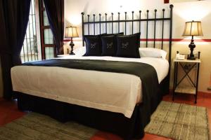 a large bed with black and white sheets and pillows at Hotel de la Paz in Guanajuato