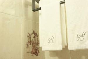 a bathroom with two towels with drawings on them at Hotel de la Paz in Guanajuato