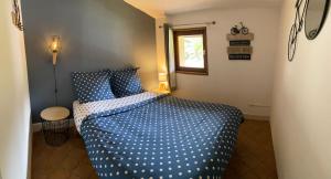 1 dormitorio con 1 cama con sábanas de lunares azules en LE VERTBRUCHE - Gîte avec superbe vue pour 15 pers, en La Bresse
