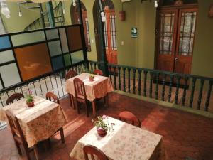 a restaurant with two tables and chairs with plants on them at El Caminante Class in Arequipa