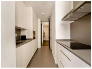uma cozinha com armários brancos e um longo corredor em Príncipe David lV Luxury Apartmet Gran Via em Madri