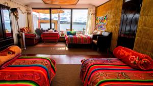 a room with several beds and a living room at Uros Samaraña Uta Lodge in Puno