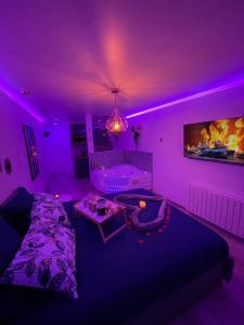 a purple living room with a bed and a tv at Bulle d'Amour in Pontault-Combault