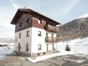 a house with a wooden roof in the snow at Brand new apartment in Livigno near ski area in Livigno