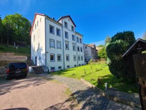 a white building with a car parked in front of it at Ferienwohnung Pension Sofia in Meißen