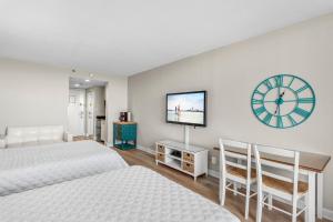 1 dormitorio con 2 camas y reloj en la pared en Sandestin Resorts, Bayside, Bay Front Studio en Destin