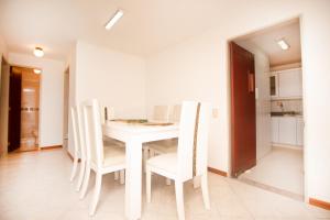 un comedor blanco con una mesa y sillas blancas en San Fernando Suite 102 - Livin Colombia, en Cali