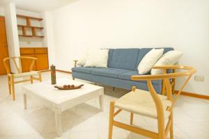 sala de estar con sofá azul y sillas en San Fernando Suite 102 - Livin Colombia, en Cali