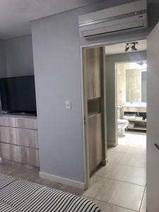 Habitación con baño con aseo y TV. en Dean Funes Suites 607 en Salta