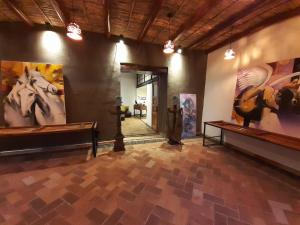 een grote kamer met schilderijen aan de muren bij Hostal Suite Le Fabrique in Cuenca