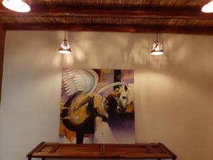 a painting on a wall with two lights at Hostal Suite Le Fabrique in Cuenca
