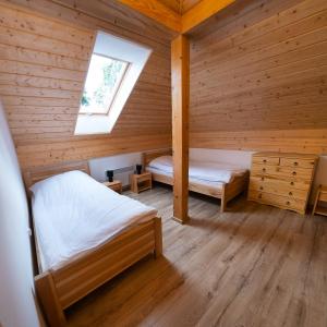 1 dormitorio con 2 camas en una cabaña de madera en Dziubanowo en Sanok