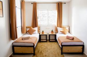 2 camas en una habitación pequeña con ventana en Mouja Surf Camp en Taghazout