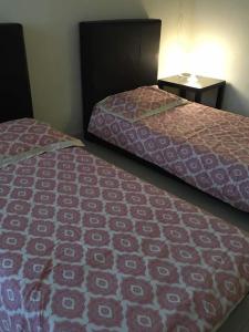 two beds sitting next to each other in a room at KS Lavender Kuala Kangsar in Kuala Kangsar