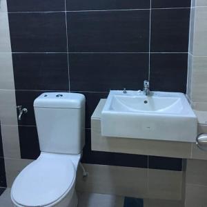 a bathroom with a white toilet and a sink at KS Lavender Kuala Kangsar in Kuala Kangsar