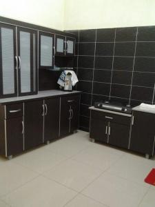 a kitchen with a black tiled wall and a stove at KS Lavender Kuala Kangsar in Kuala Kangsar