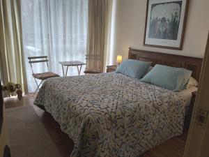 a bedroom with a bed and a chair and a window at Quinta Vergara Montaña in Viña del Mar