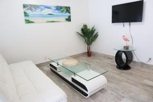 a living room with a white couch and a glass table at SII Luxury 1 Bedroom close to the beach in West Palm Beach