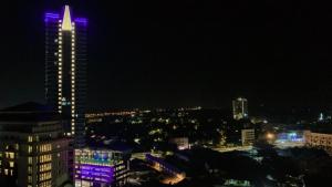 a tall building with purple lights on it at night at KTC TRADE CENTRE in Kota Bharu