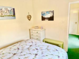 um quarto com uma cama e uma cómoda em Cosy 2 bed cottage next to Fota Wildlife Park em Cork