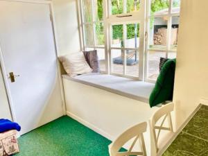 a room with a window with a bench and a chair at Cosy 2 bed cottage next to Fota Wildlife Park in Cork