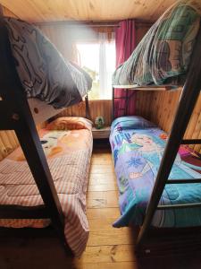 מיטה או מיטות קומותיים בחדר ב-Cabañas Los Castaños Chovellén