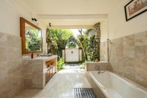 a bathroom with a tub and a sink at Alam Jiwa Ubud in Ubud