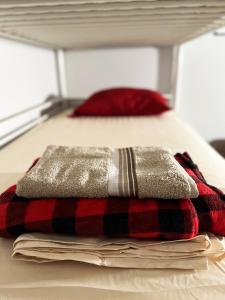 a pile of blankets sitting on top of a bed at Pineapple Hostel in Los Angeles