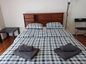 a bed with two pillows on top of it at Rooms in the apartment (Leontiou) in Athens