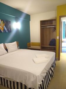 een slaapkamer met een groot bed met een blauwe muur bij Grein Solar das Águas Park Resort in Olímpia