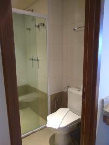ein Badezimmer mit Toilette und Glasdusche in der Unterkunft Grein Solar das Águas Park Resort in Olímpia